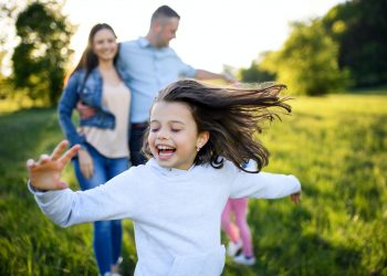 Happy family with two small daughters having fun outdoors in spring nature Happy family with two small daughters having fun outdoors in spring nature